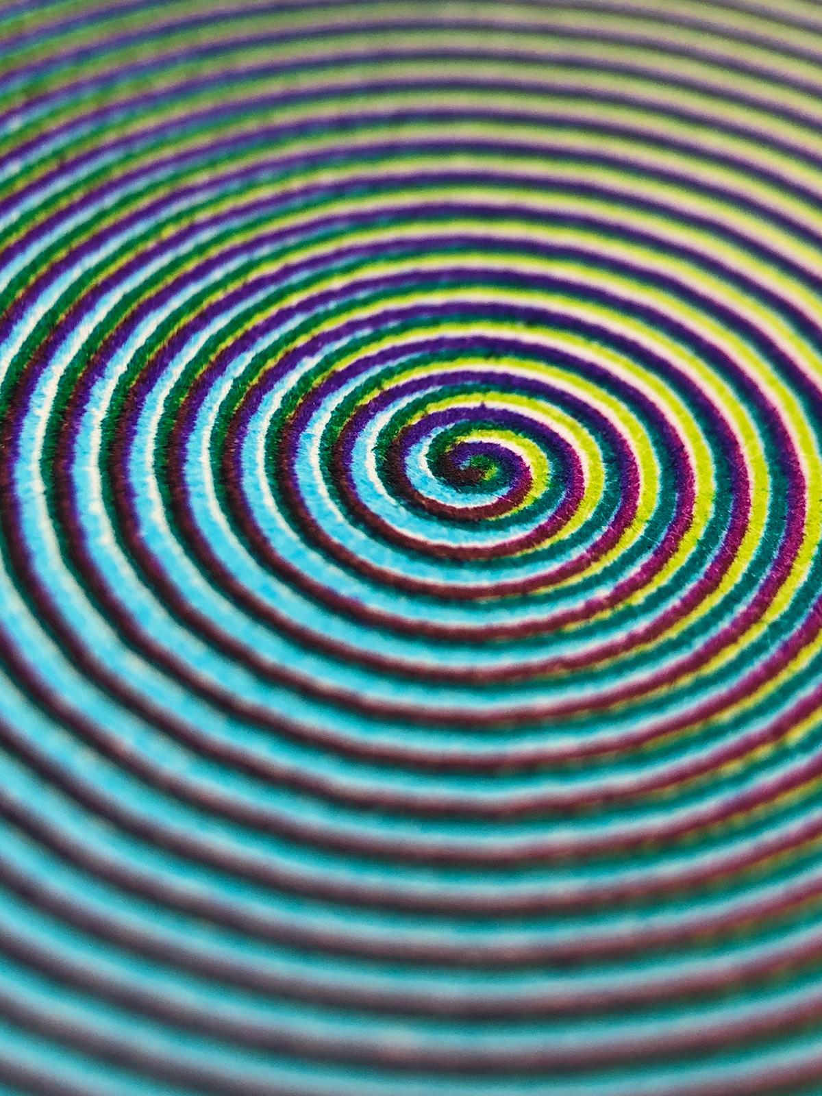 The same close-up view of a second spiral, made up of shades of green, blue, and lilac
